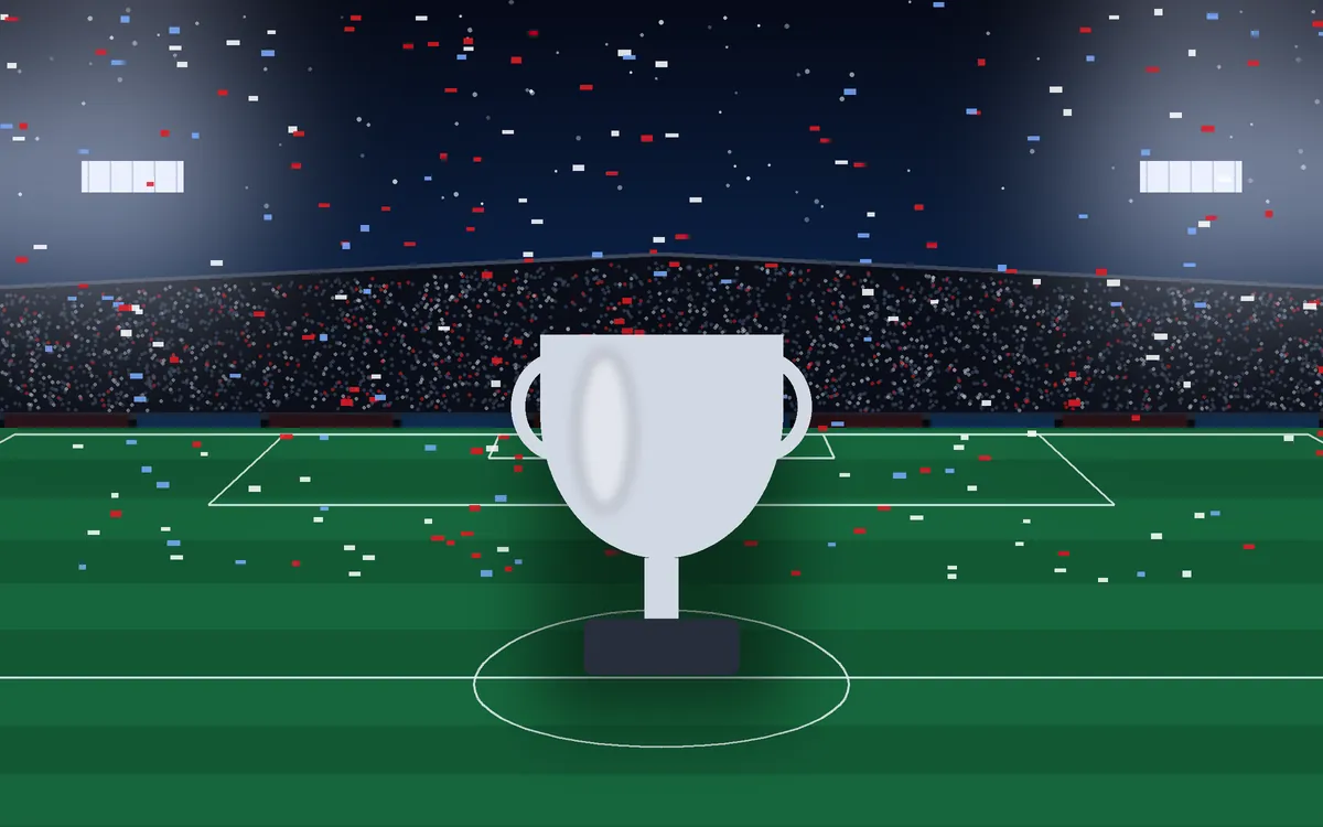 Trophy on a floodlit pitch with confetti